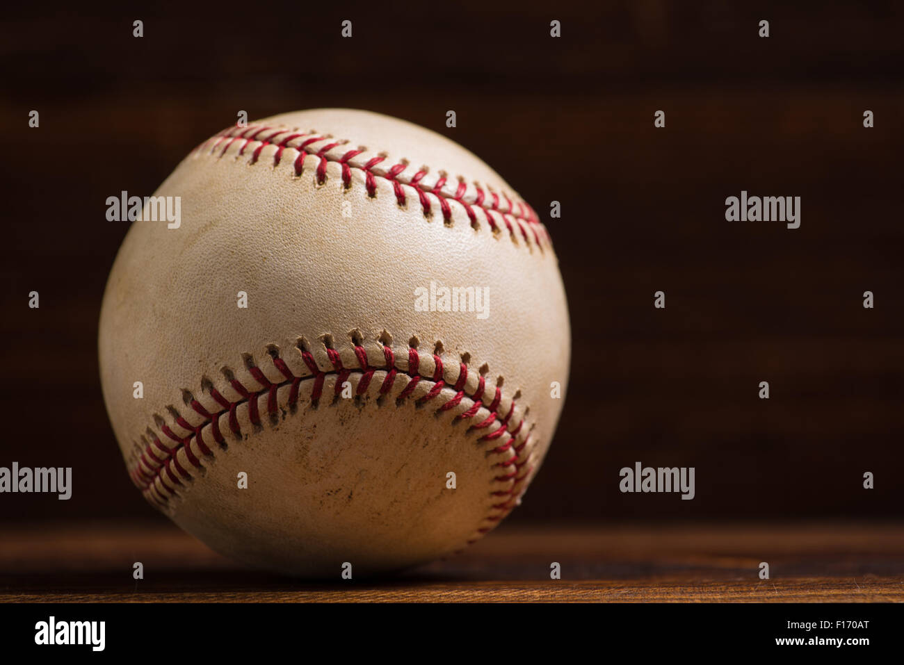 Ein weißes Leder Baseball auf einer Holzbank-Hintergrund Stockfoto