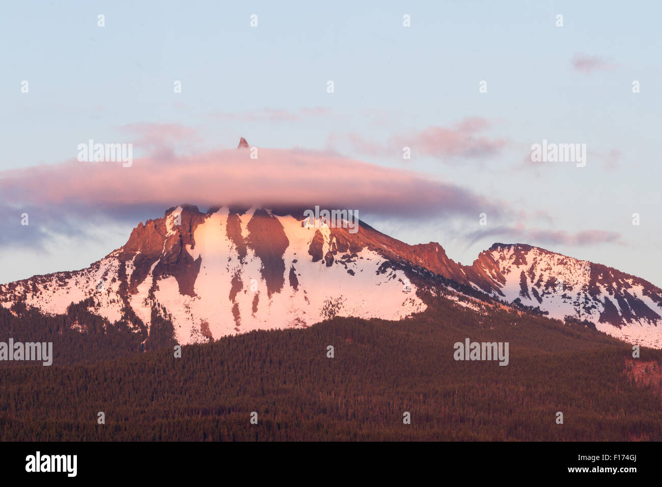 Mount Thielsen bei Sonnenuntergang mit einem rötlichen Schimmer und einem anhaltenden Nebel um die Spitze des Berges Stockfoto