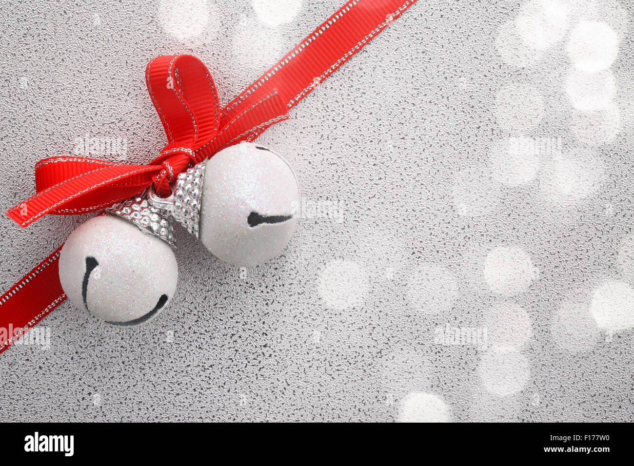 Weiße Jingle Bell mit Schleife auf festlichen Hintergrund Stockfoto
