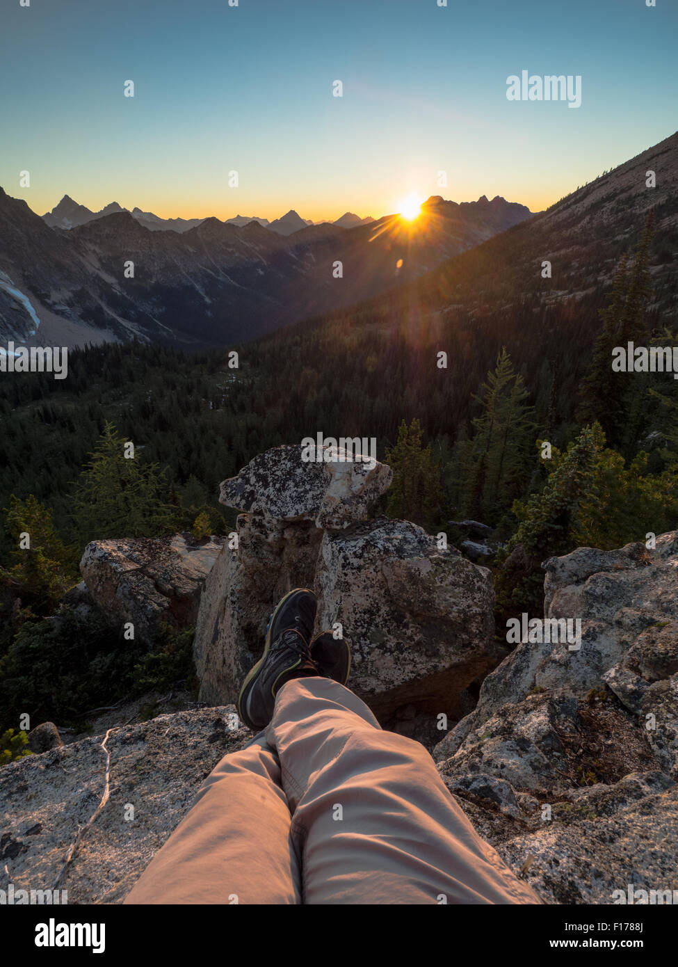 Eine einsame Person abwickelt und entspannt auf einer untergehenden Sonne hinter den Bergen des nördlichen Washington. Stockfoto