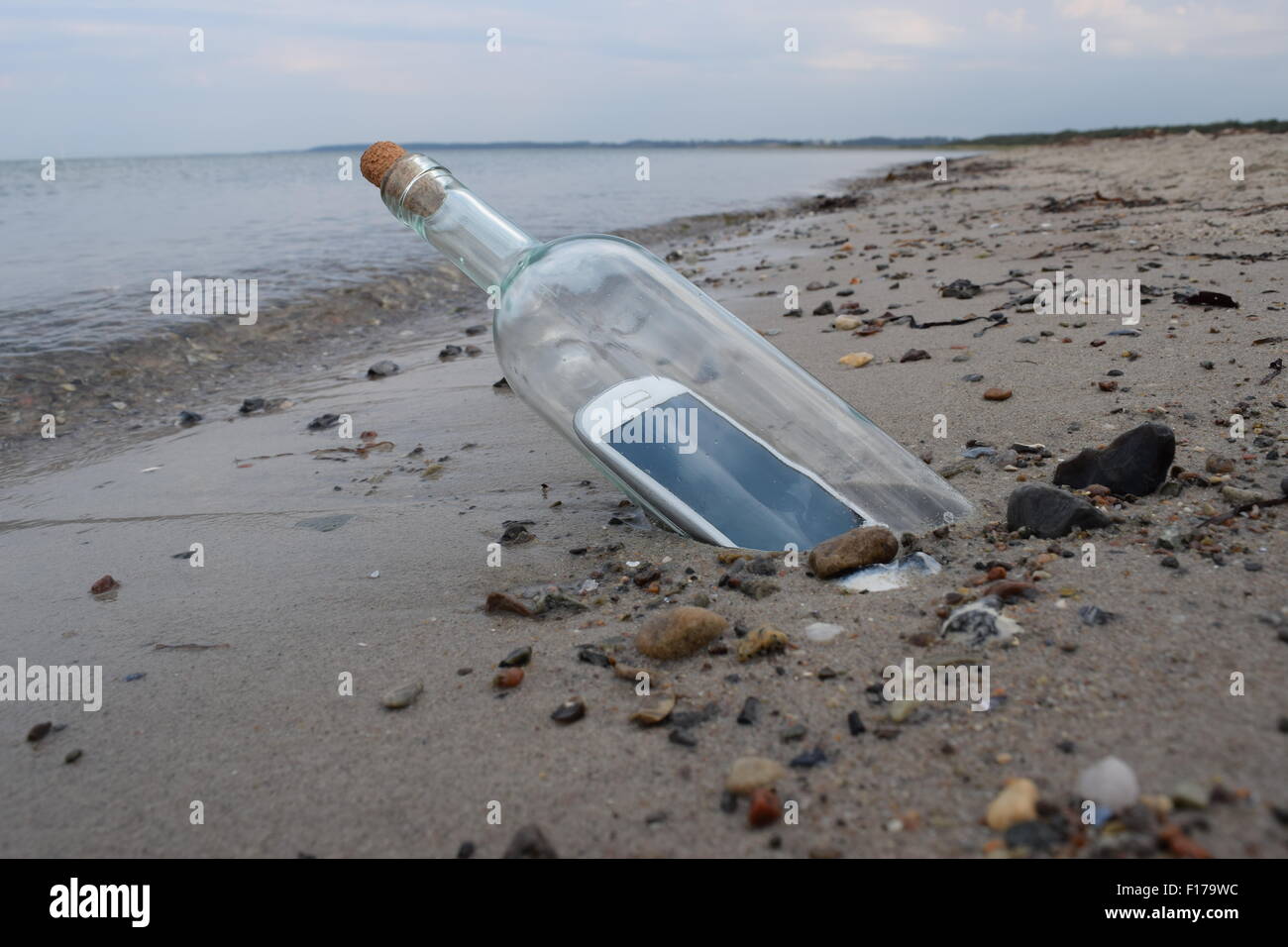 Digital native Castaway Hilfe eine Botschaft in einer Flasche. Stockfoto