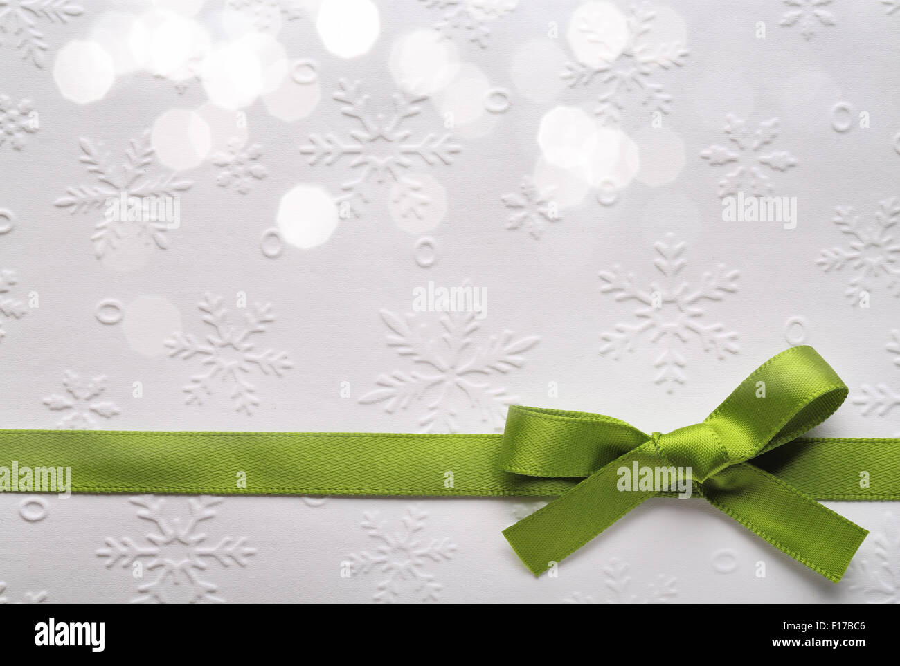 Grüne Schleife mit Bokeh, strukturiertem Papierhintergrund. Stockfoto
