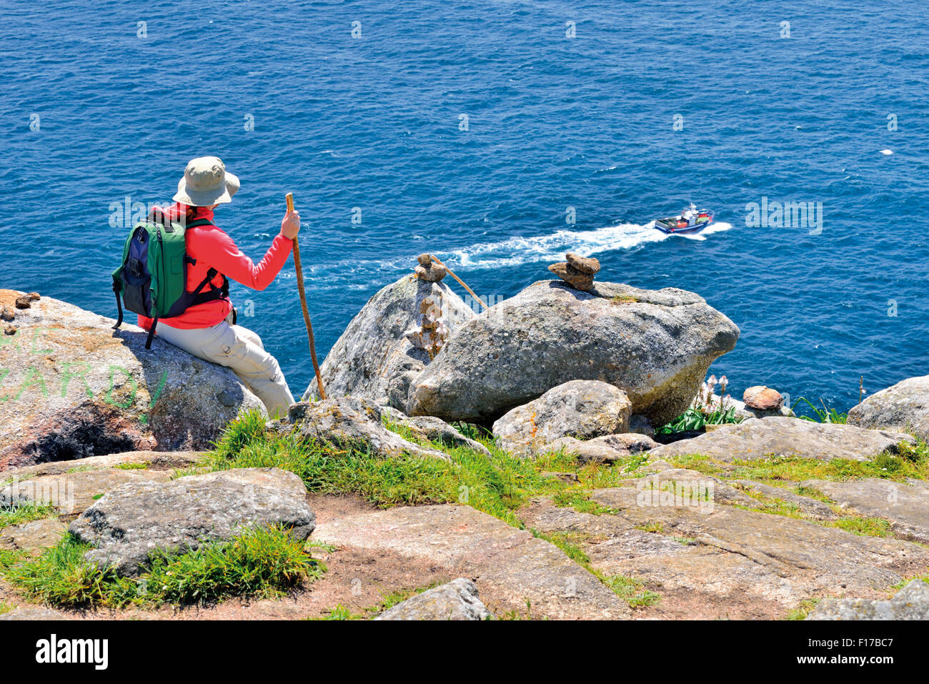 Spanien, Jakobsweg: Pilger sitzen, Blick auf den Ozean bei Kap Fisterra Stockfoto