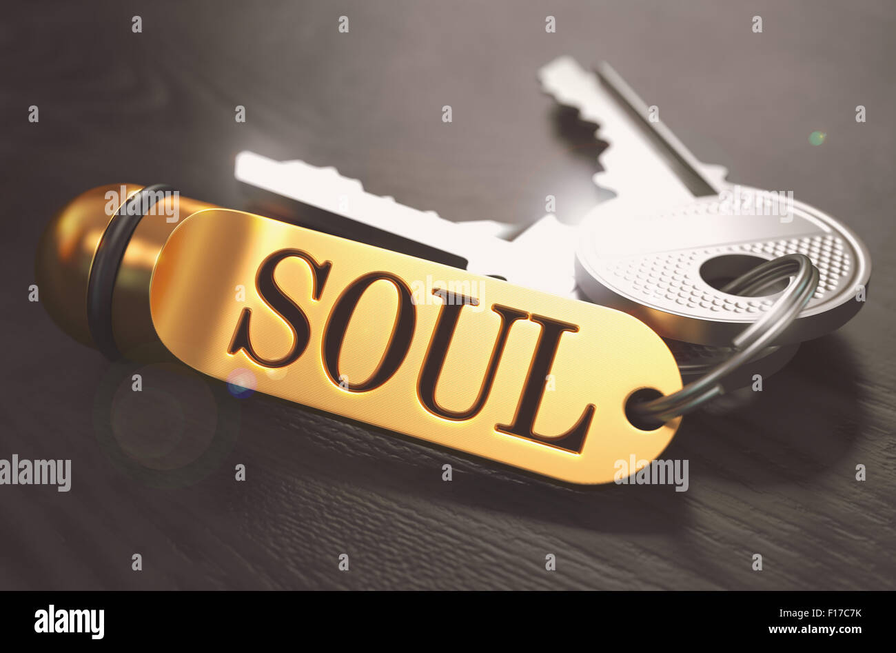 Schlüssel und goldenen Schlüsselanhänger mit dem Wort Seele über schwarzer Holztisch mit Unschärfe-Effekt. Getönten Image. Stockfoto