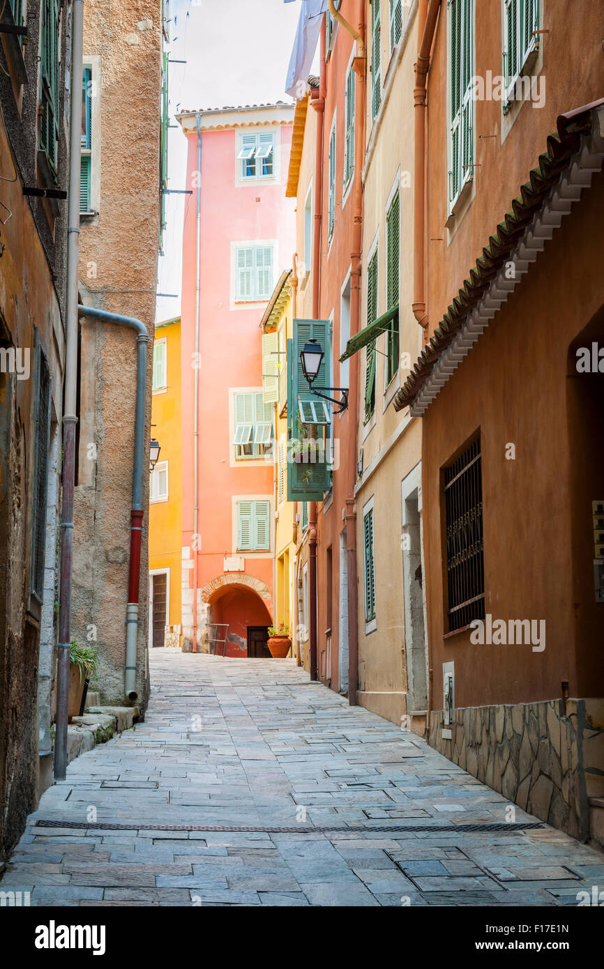 Schmale gepflasterte Straße mit hellen Gebäuden in der mittelalterlichen Stadt Villefranche-Sur-Mer an der Côte d ' Azur, Frankreich. Stockfoto