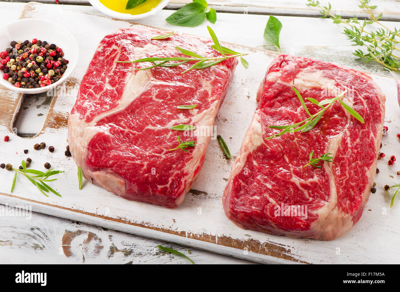 Zwei rohen Rindfleisch-Steaks auf einem Holzbrett. Stockfoto