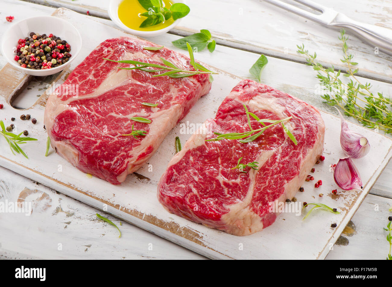Zwei rohen Rindfleisch-Steaks auf einem Holzbrett. Stockfoto