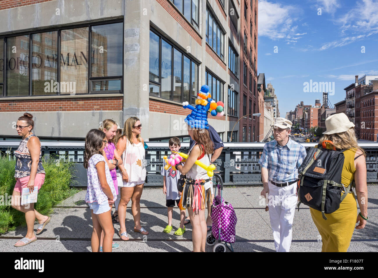 Fußgänger auf der High Line Umweg um ambulante Ballon Lieferanten tragen eines eigenen fantasievollen Kreationen & einen weiteren Stockfoto