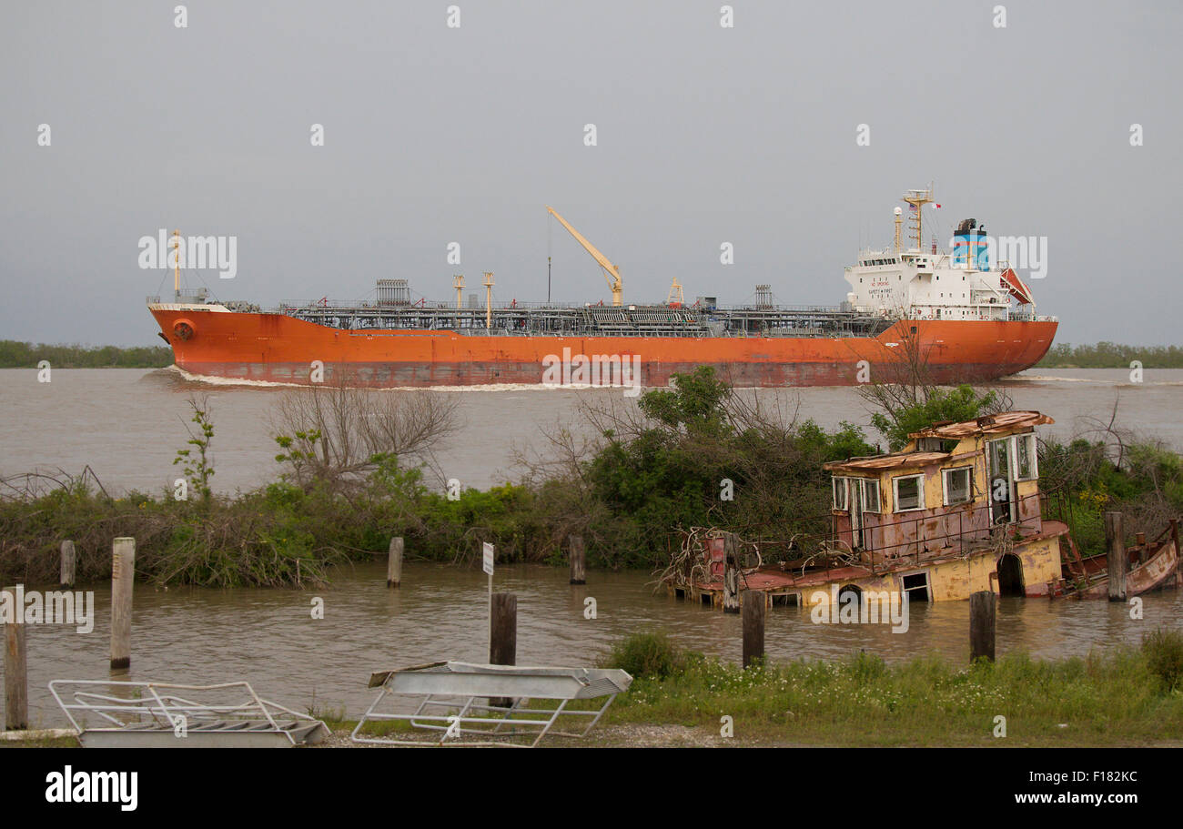 Massive Kraftstofftanker ziehen in den Mississippi River in Venedig Louisiana. Sie sehen eine versunkene Schlepper im Vordergrund Stockfoto