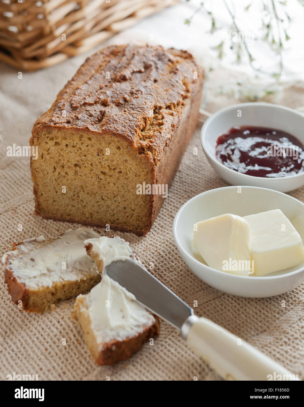 Ein Laib hausgemachte paleo Brot mit Butter und Marmelade. Stockfoto