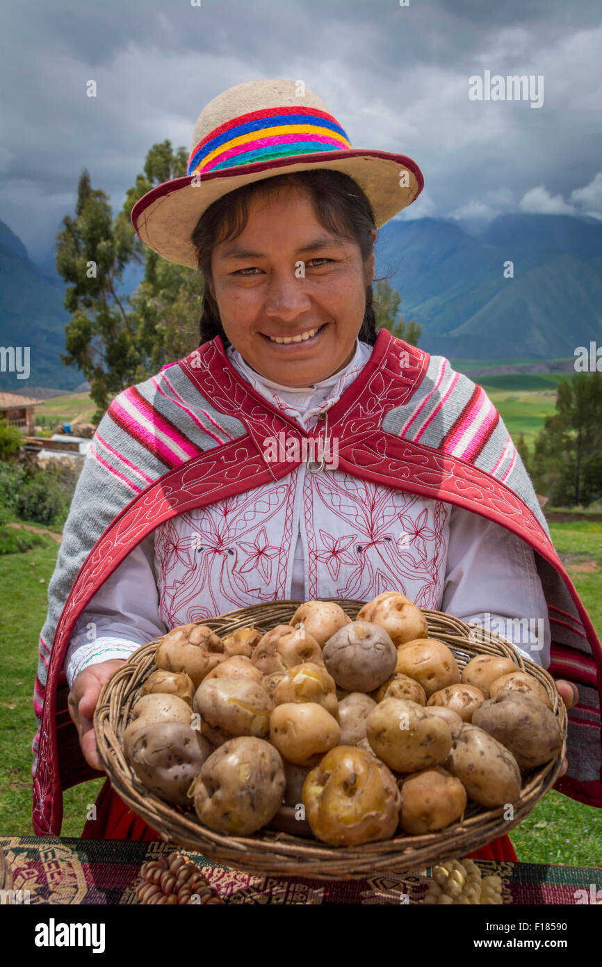 Quechua-Frau hält Korb mit Kartoffeln und tragen traditionelle Kleidung und Hut in Misminay Dorf, Heiliges Tal, Peru. Stockfoto