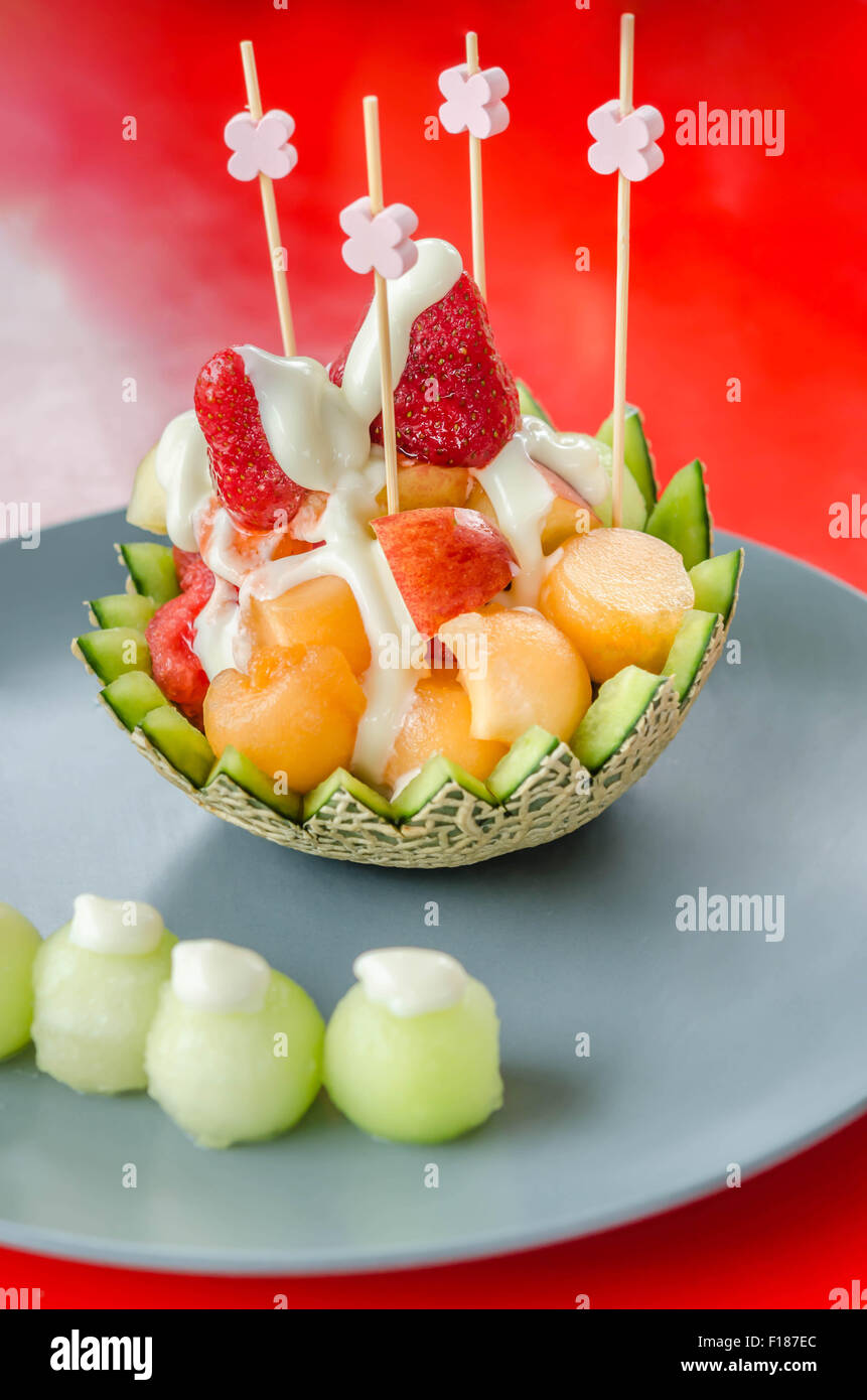 Frischer Obstsalat in Melone Schüssel auf Teller Stockfoto