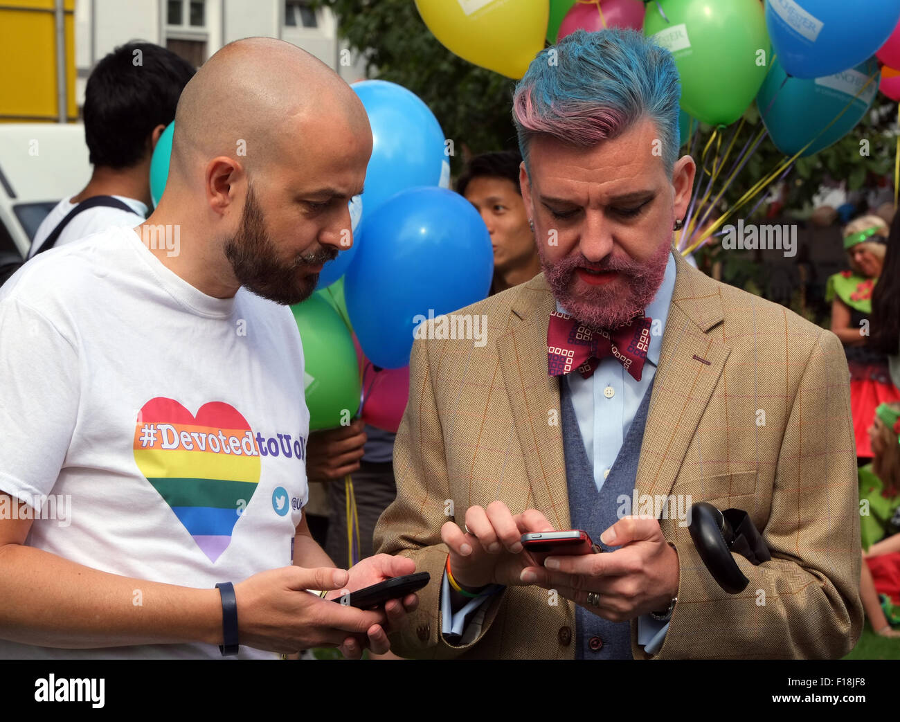 Schwule Männer mit ihren Smartphones während der Vorbereitung für die Manchester Pride 2015 große Parade durch die Innenstadt Stockfoto