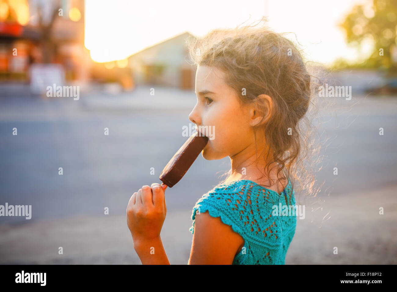 Mädchen, essen Eis außerhalb einer Seitenansicht Stockfoto