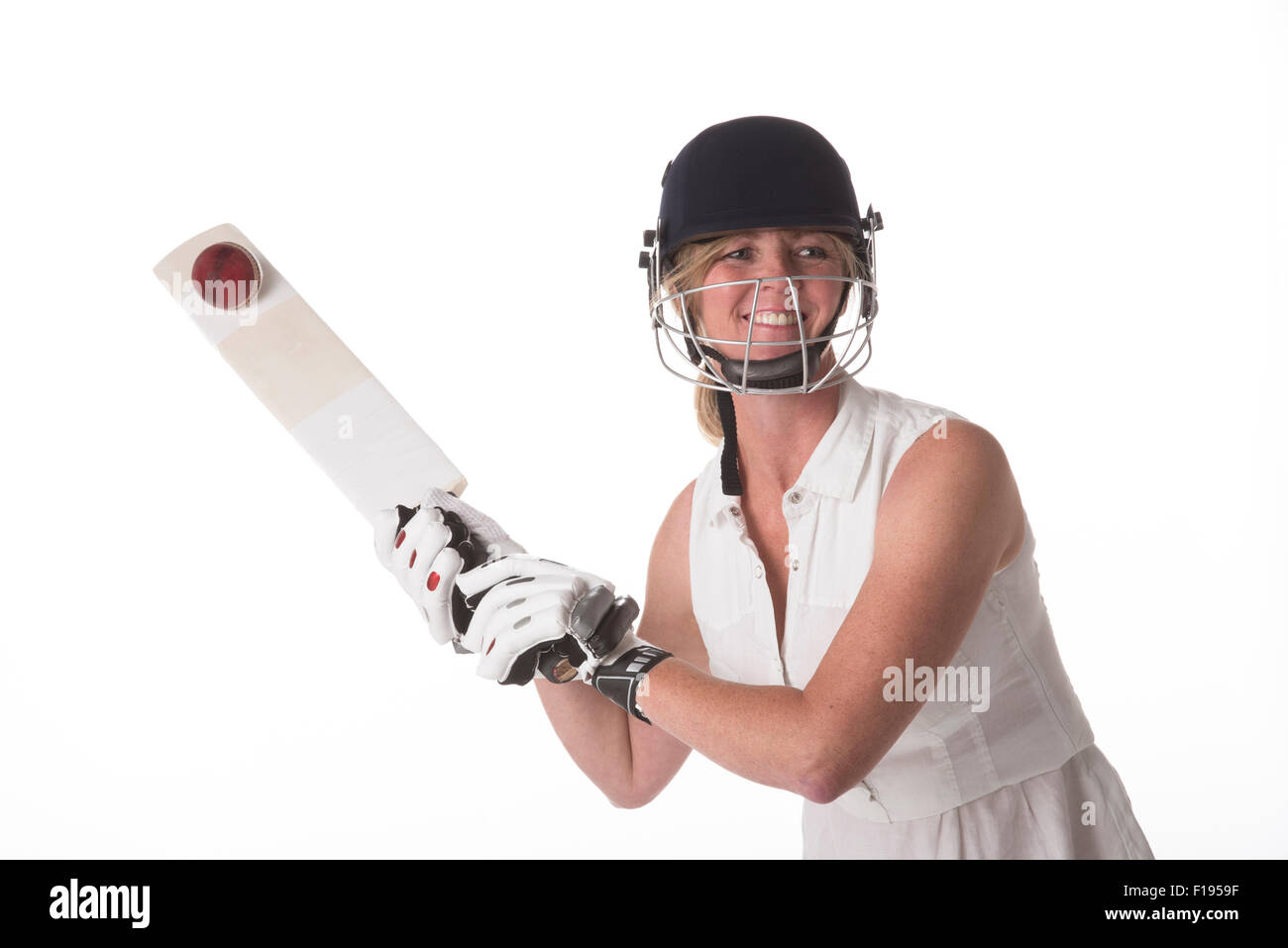 Weibliche Club Cricketspieler schlagen Cricketball mit einer Fledermaus-Grille Stockfoto