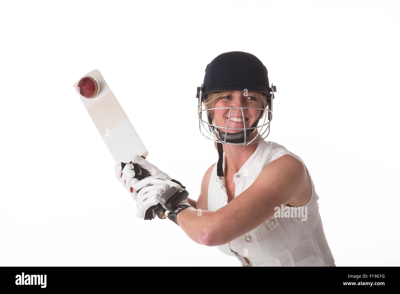 Weibliche Club Cricketspieler schlagen Cricketball mit einer Fledermaus-Grille Stockfoto