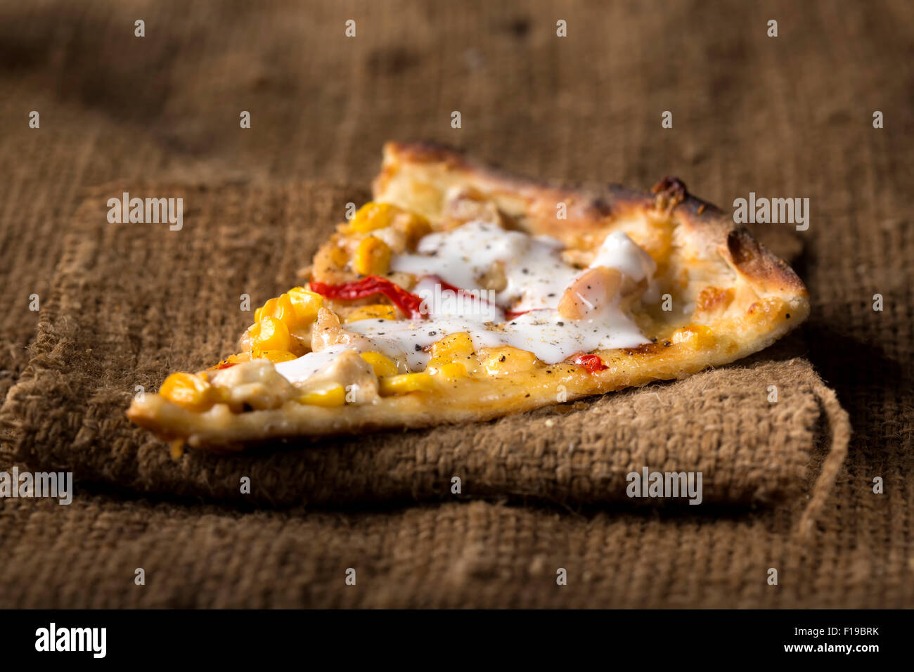 Ein Stück Pizza Al Pollo auf Holz mit Tomate Stockfoto