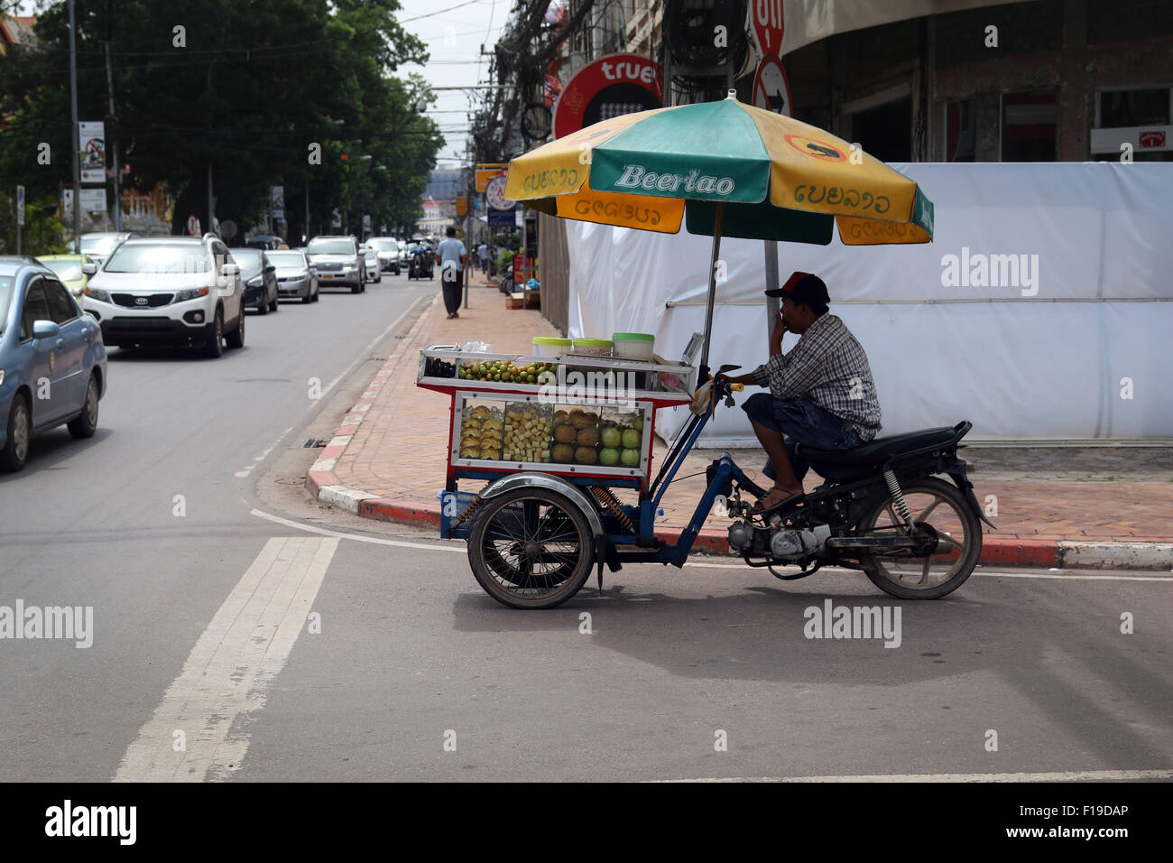 Verkauf von Obst Mann trinkt Vientiane Laos Stockfoto