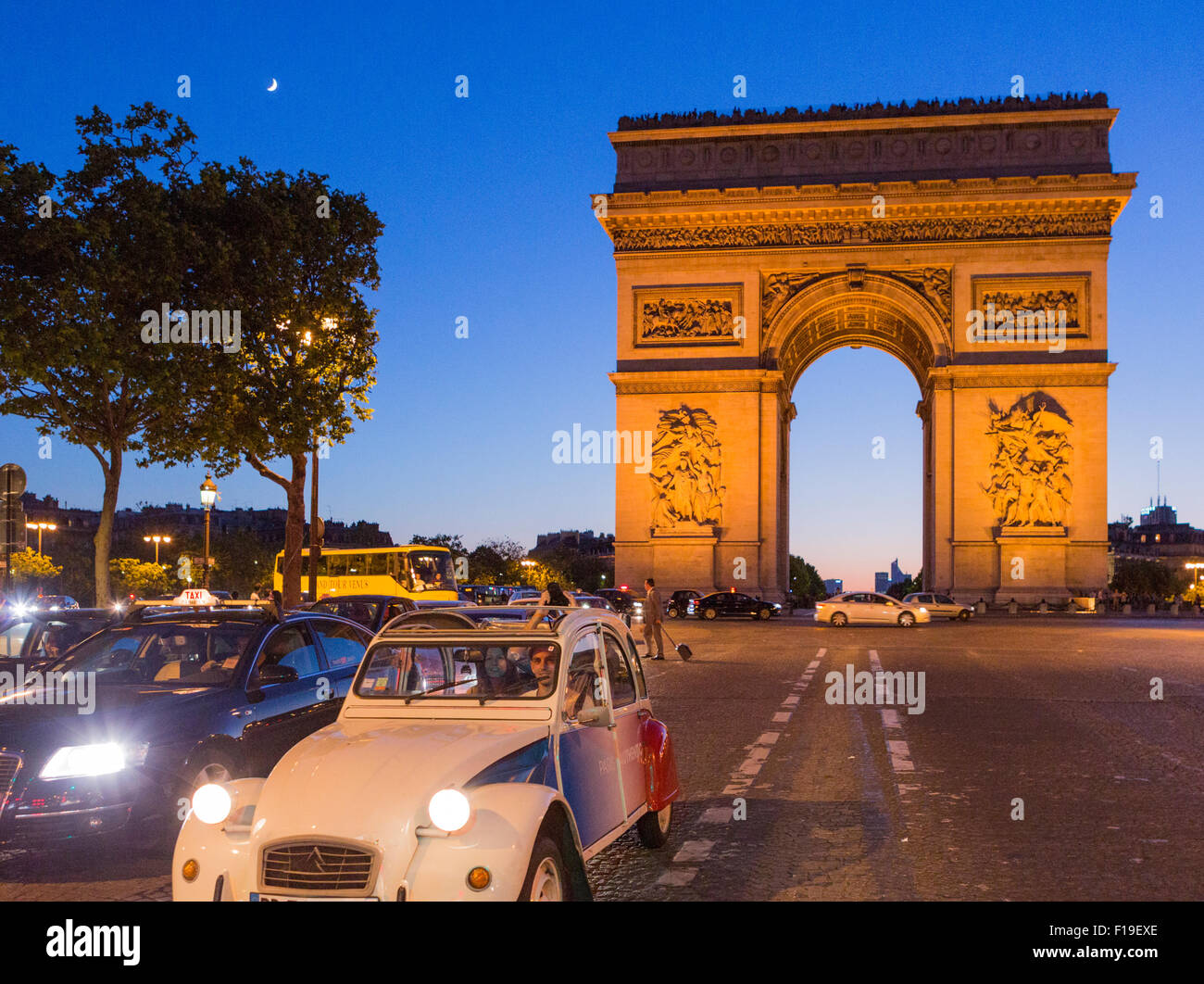 Citroen Oldtimer auf der Avenue des Champs Elysees vor ot den Arc de Triomphe in der Abenddämmerung mit Mondsichel, Paris Stockfoto