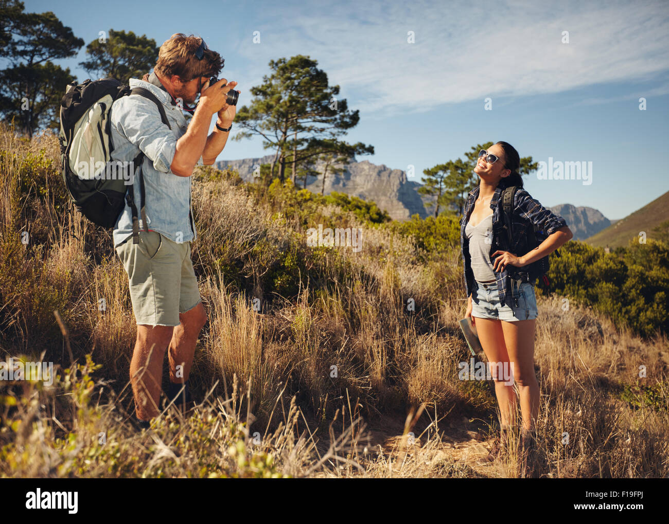 Im Freien Schuss von touristischen paar Wandern und Fotografieren mit der Kamera. Mann unter Bild der Freundin im Lande. Paar auf Stockfoto