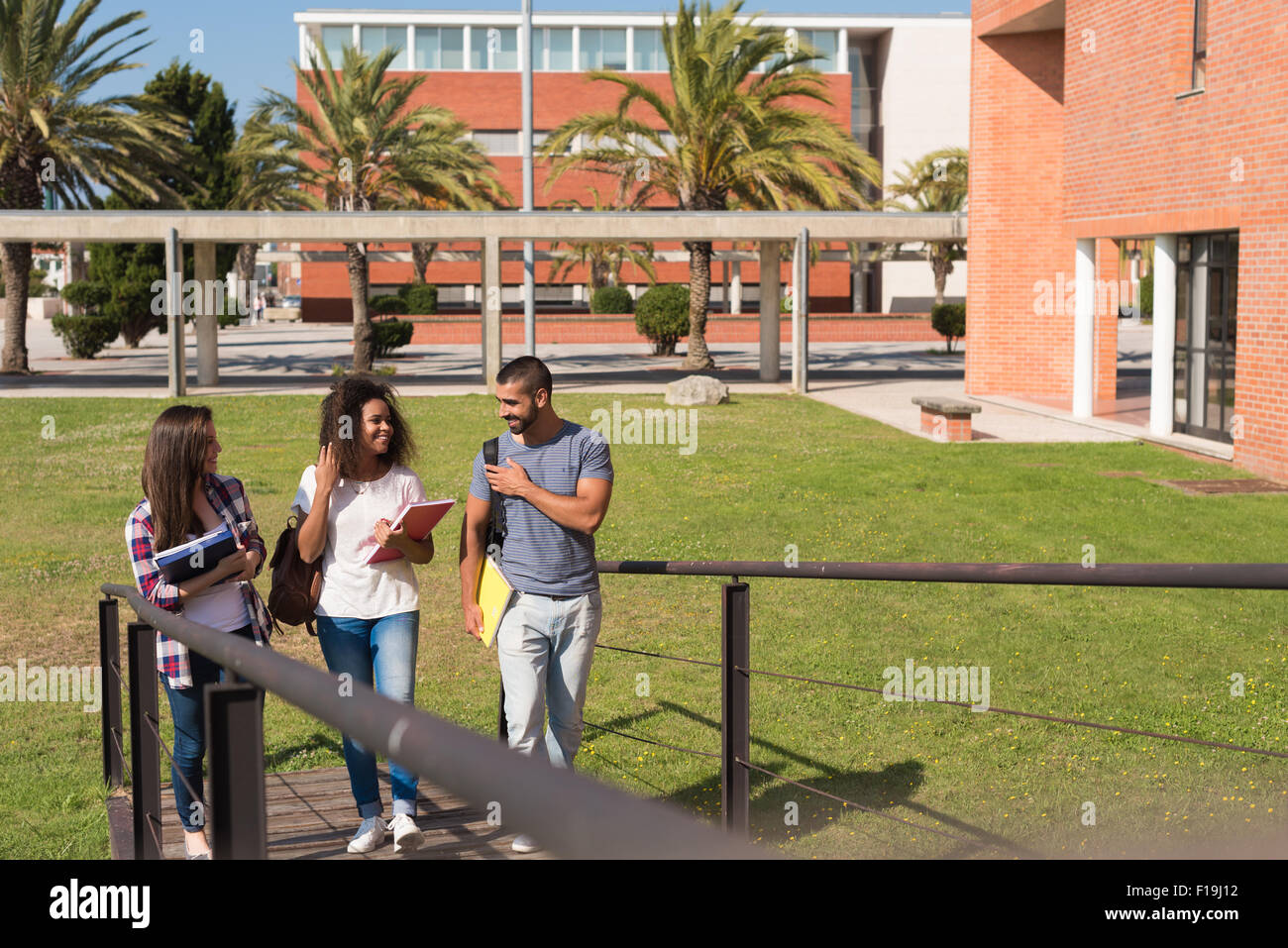 Gruppe von Studenten sitzen auf Schulgelände Stockfoto