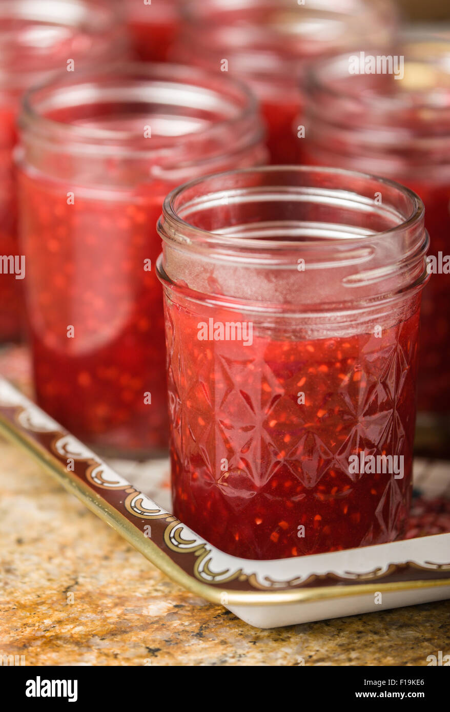 Gläser von hausgemachte Himbeermarmelade.  Füllen Sie Ihr wartet auf (desinfiziert) Gläser sofort zu innerhalb 1/2 Zoll der Spitzen der Ihre Marmelade. Stockfoto