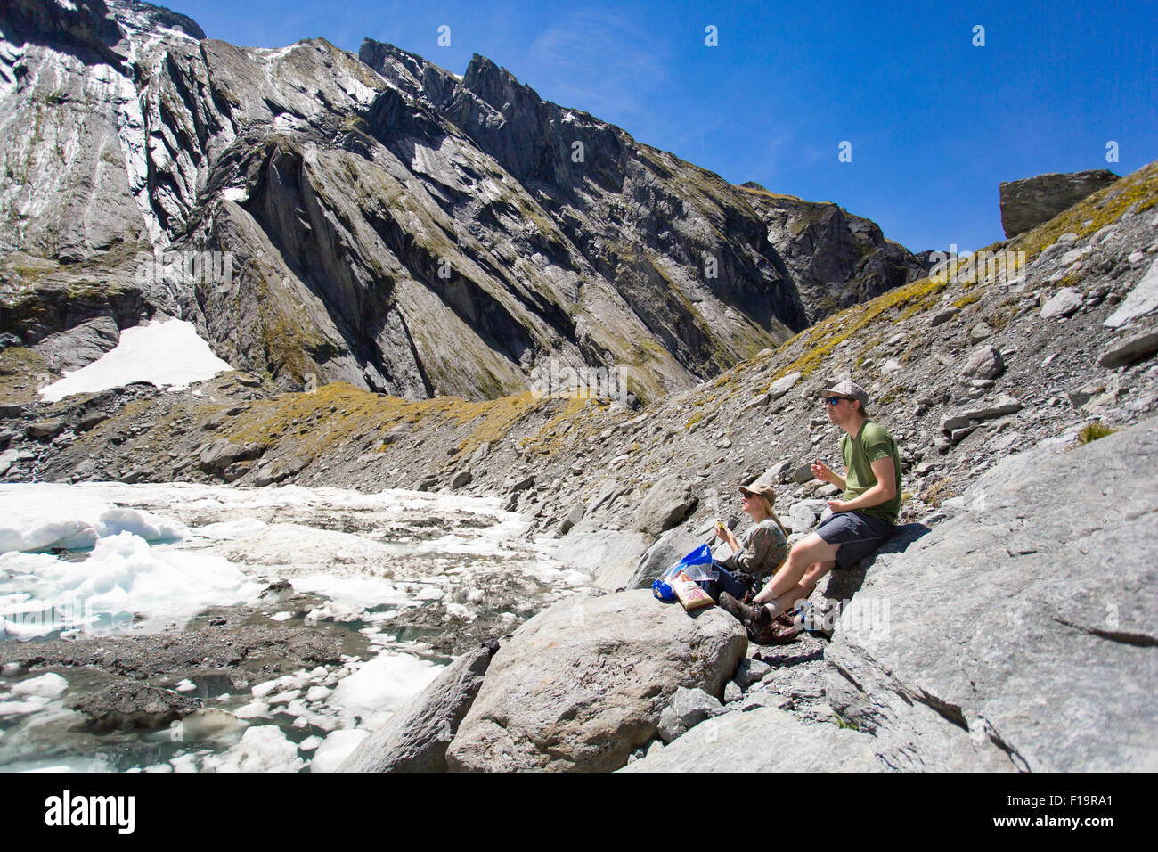New Zealand aka Aotearoa, Südinsel, Mt Aspiring Nationalpark, Lake Tiegel, Touristen Mittagessen an einem Eisberg-See. Stockfoto
