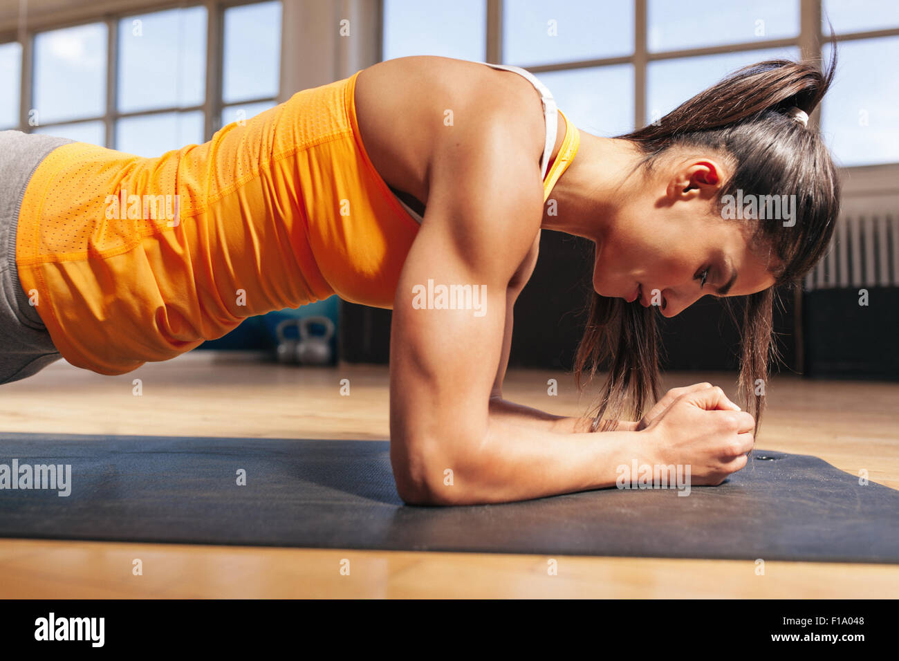 Seitenansicht der attraktiven jungen Frau Kern Übung auf Fitness-Matte in der Turnhalle. Weiblich, Liegestütz im Health Club zu tun. Stockfoto