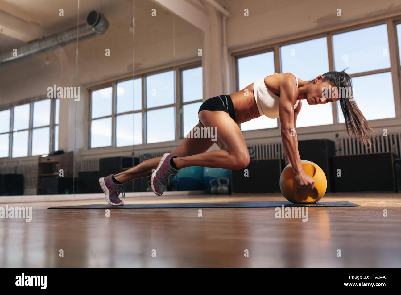 Porträt von Passform und muskulöse Frau dabei intensive Core Training mit Kettlebell im Fitness-Studio. Weibchen im Crossfit Gym trainieren. Stockfoto