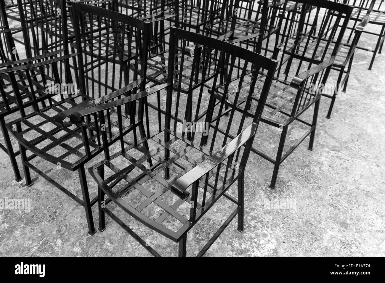 Vintage schwarze Metall-Stühle stehen in einer Reihe Stockfoto