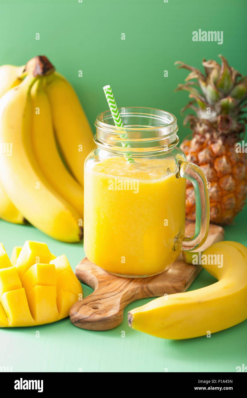gesunde gelbe Smoothie mit Mango-Ananas-Banane in Einweckgläser Stockfoto