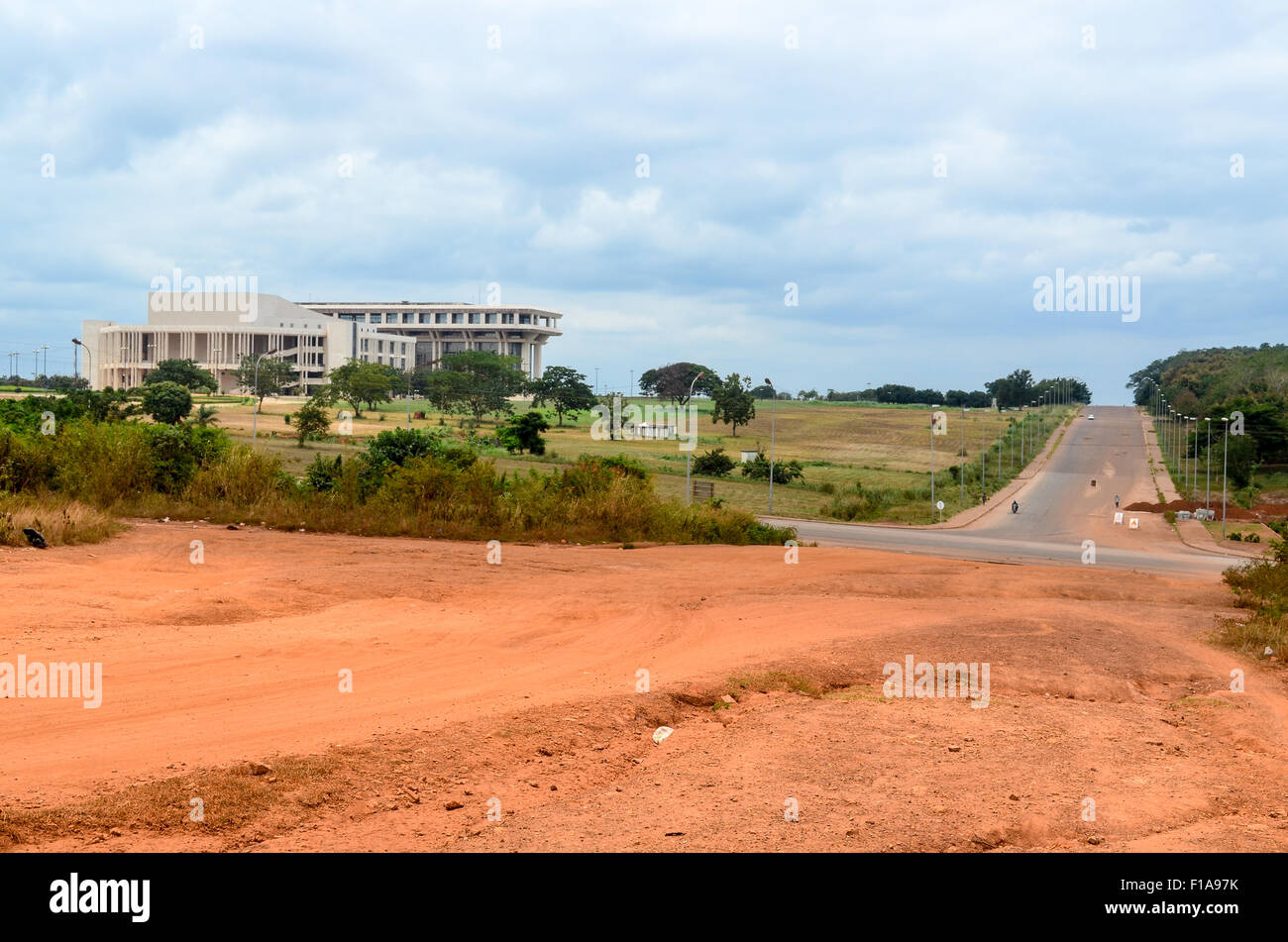 Rote Erde Feldweg in Yamoussoukro, Afrika, in der Nähe der Fondation Felix Houphouet-Boigny Gebäudes Stockfoto