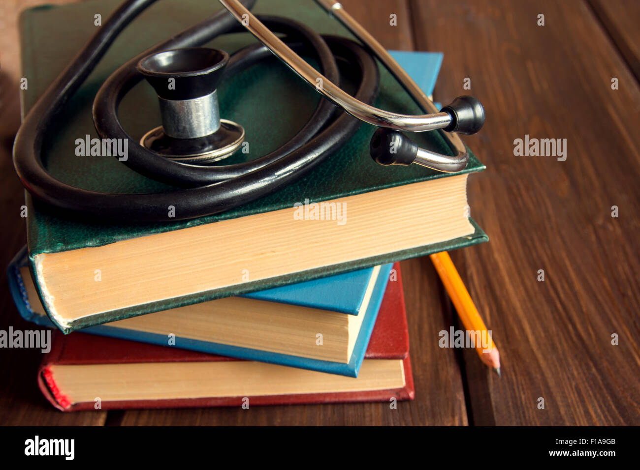 Stethoskop und alte Bücher über Holztisch mit Textfreiraum, medizinische Ausbildungskonzept Stockfoto