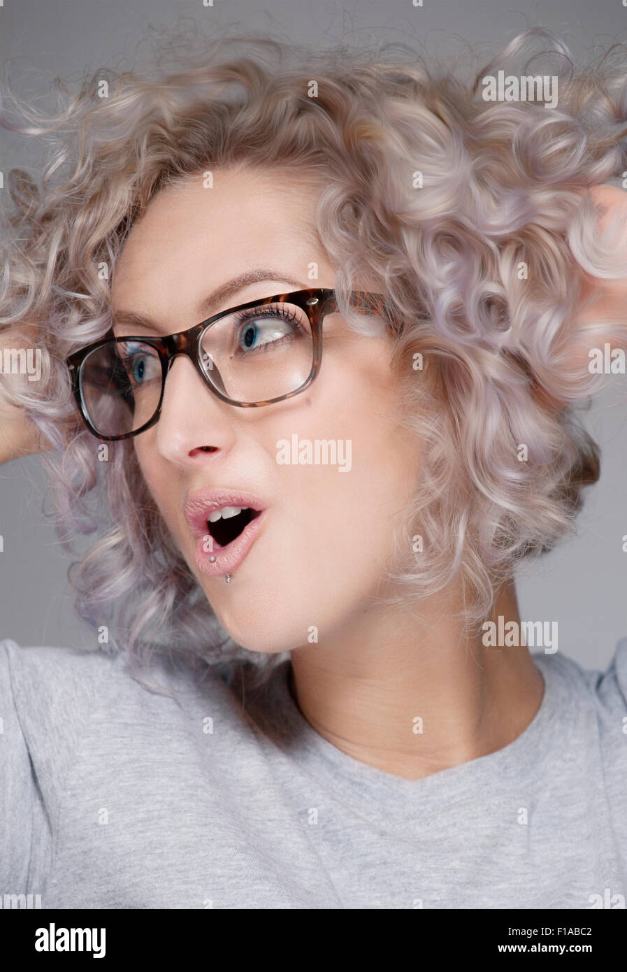 Eine weiße europäische Frau Alter 20-25 mit Brille. Der Schuss ist eine Porträtaufnahme in einem Studio. Stockfoto