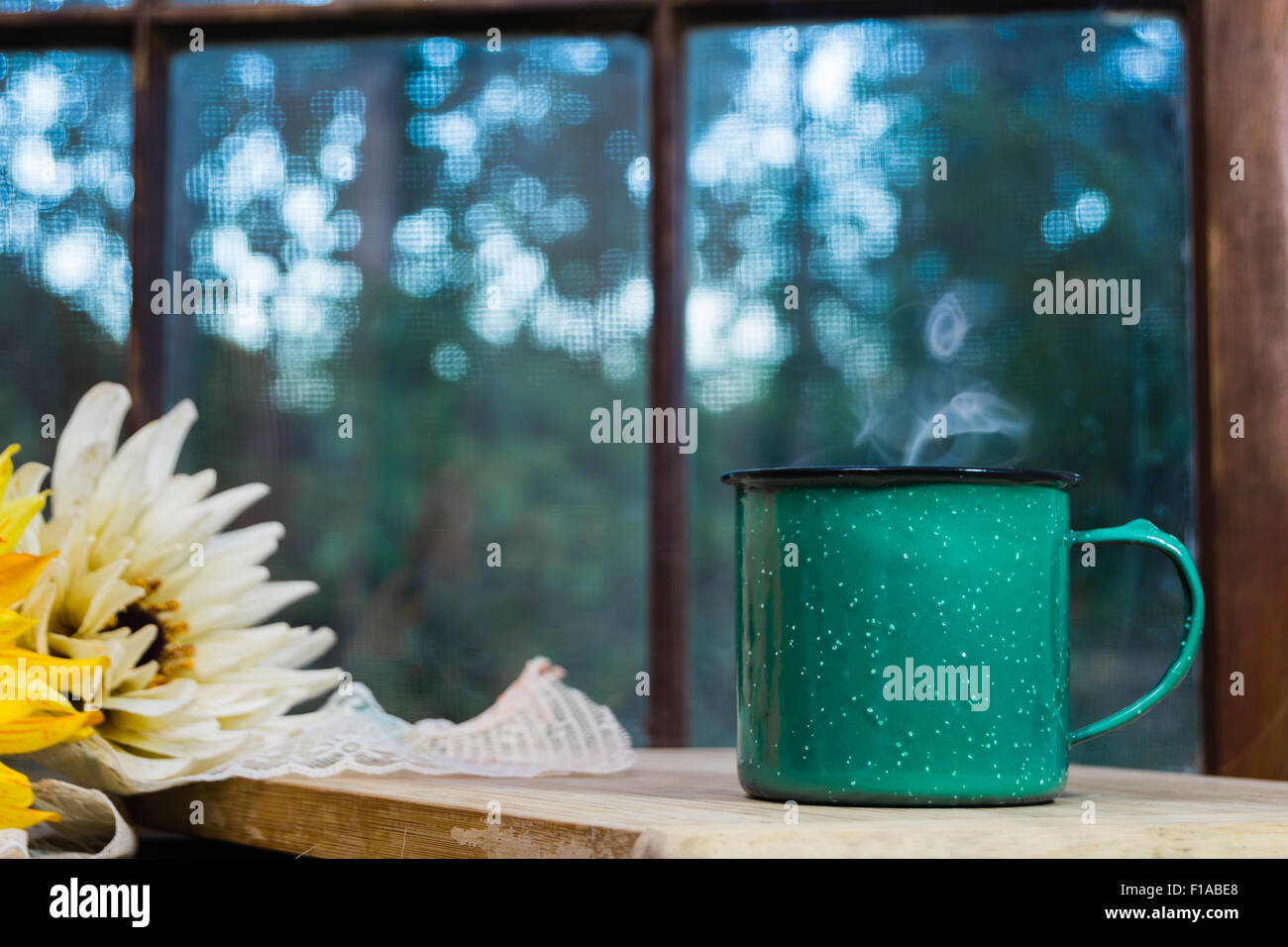 Grüner Kaffeetasse dampfenden mit verglaste Fenster im Hintergrund. Stockfoto