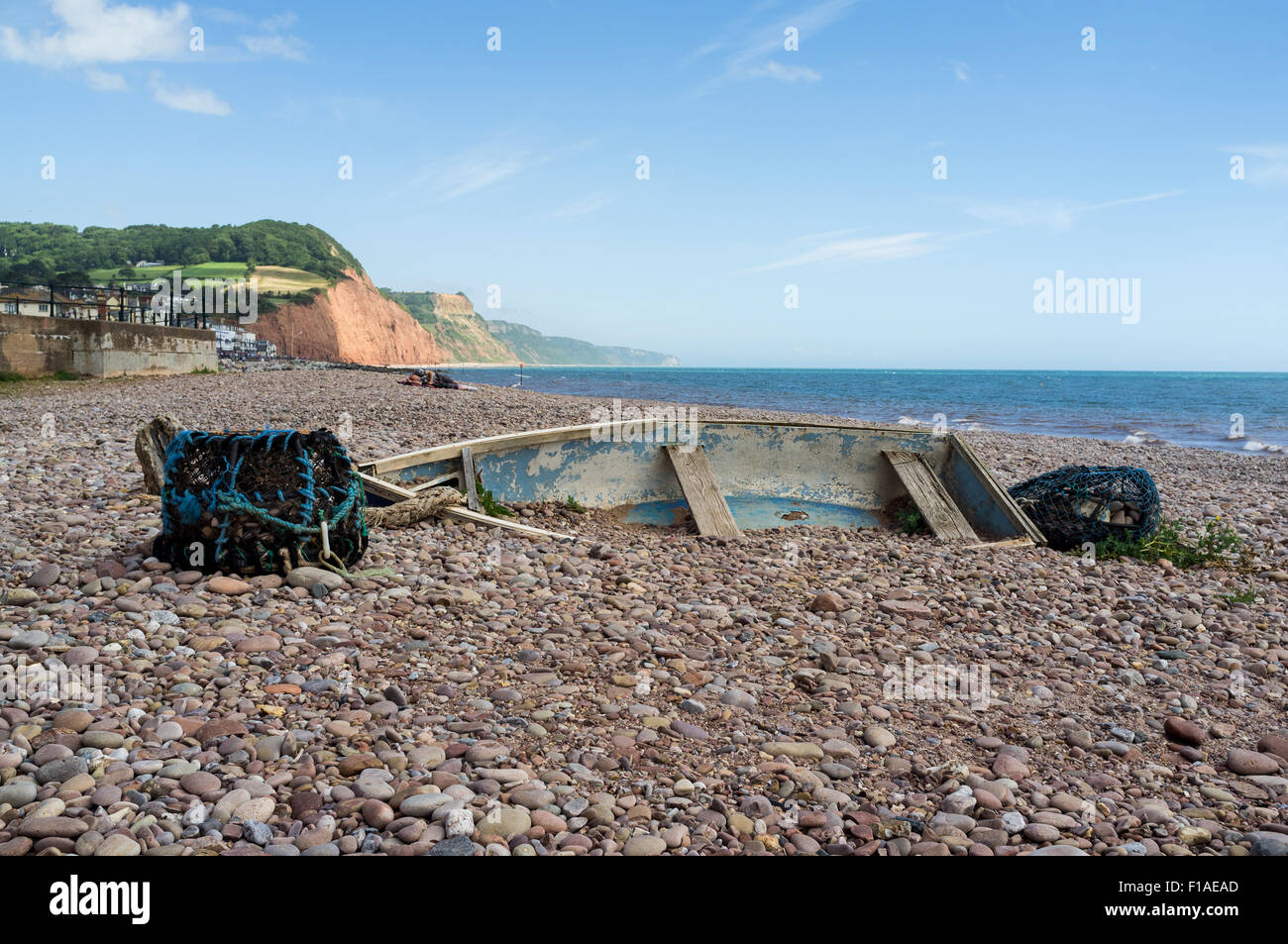 Das Wrack der eine alte hölzerne Klinker-Jolle, die halb im Sand und Kieselsteine am Strand von Sidmouth begraben. Stockfoto