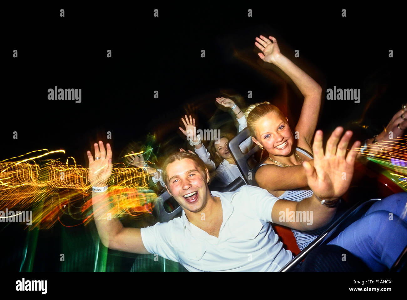 Eine junge Erwachsene Paar genießt eine Achterbahnfahrt in der Nacht bei Adventure Island. Southend-on-Sea. Essex. UK Stockfoto