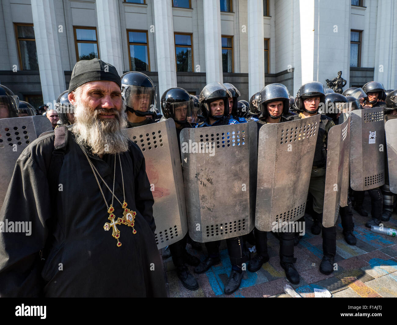 Werchowna Rada, Ukraine. 31. August 2015. Orthodoxer Priester im Hintergrund Polizei abgesperrt das Verkhovna Rada der Ukraine. --Die Gegner der Änderungen der ukrainischen Verfassung Zusammenstoß mit der Polizei Kredit: Igor Golovnov/Alamy Live News Stockfoto