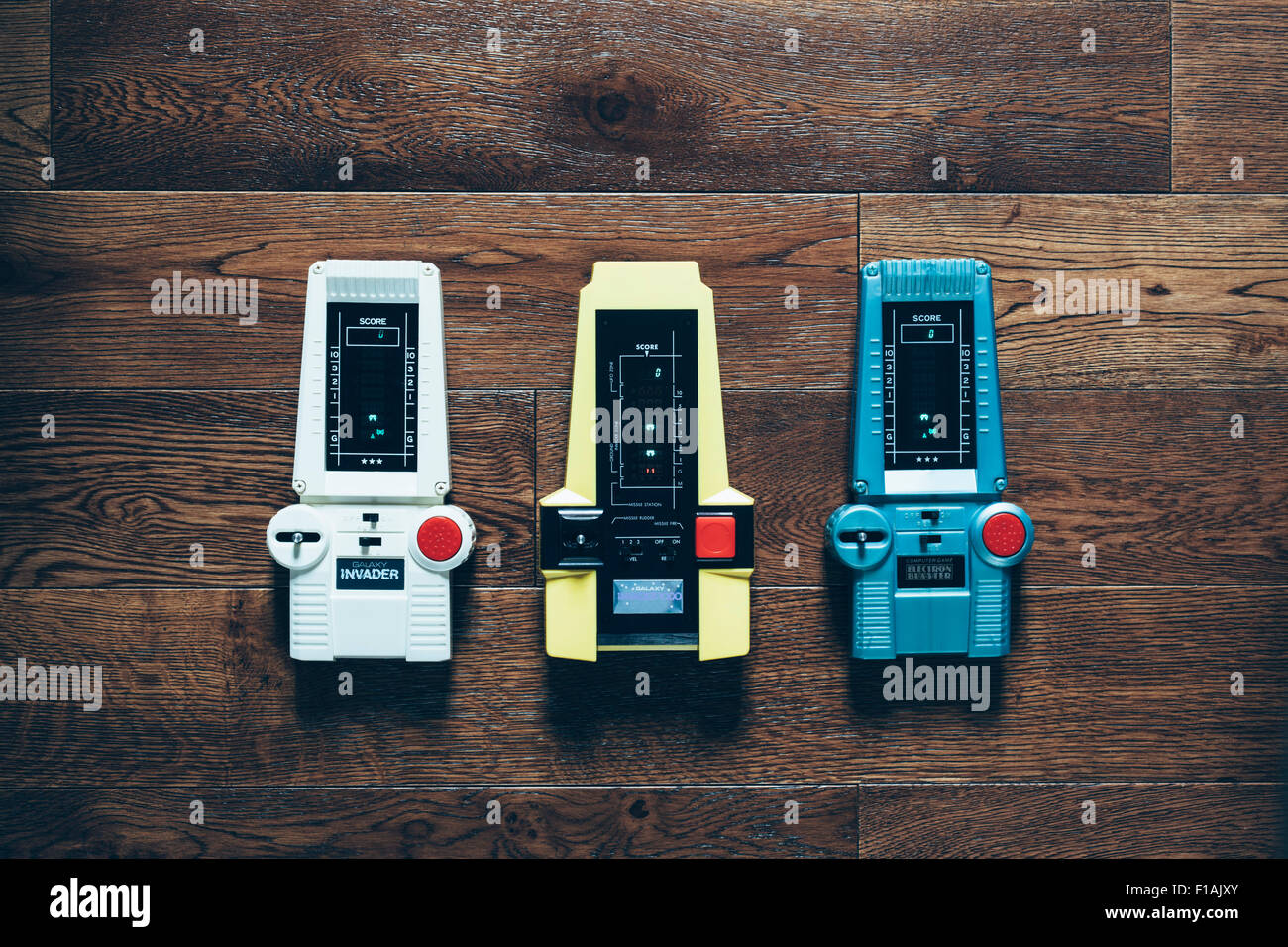 Drei Vintage/Retro hand elektronische Space Invader Spiele aus den 70er Jahren gehalten, mit Vakuum Fluoreszenz Display (VFD), Batterie betrieben. Stockfoto