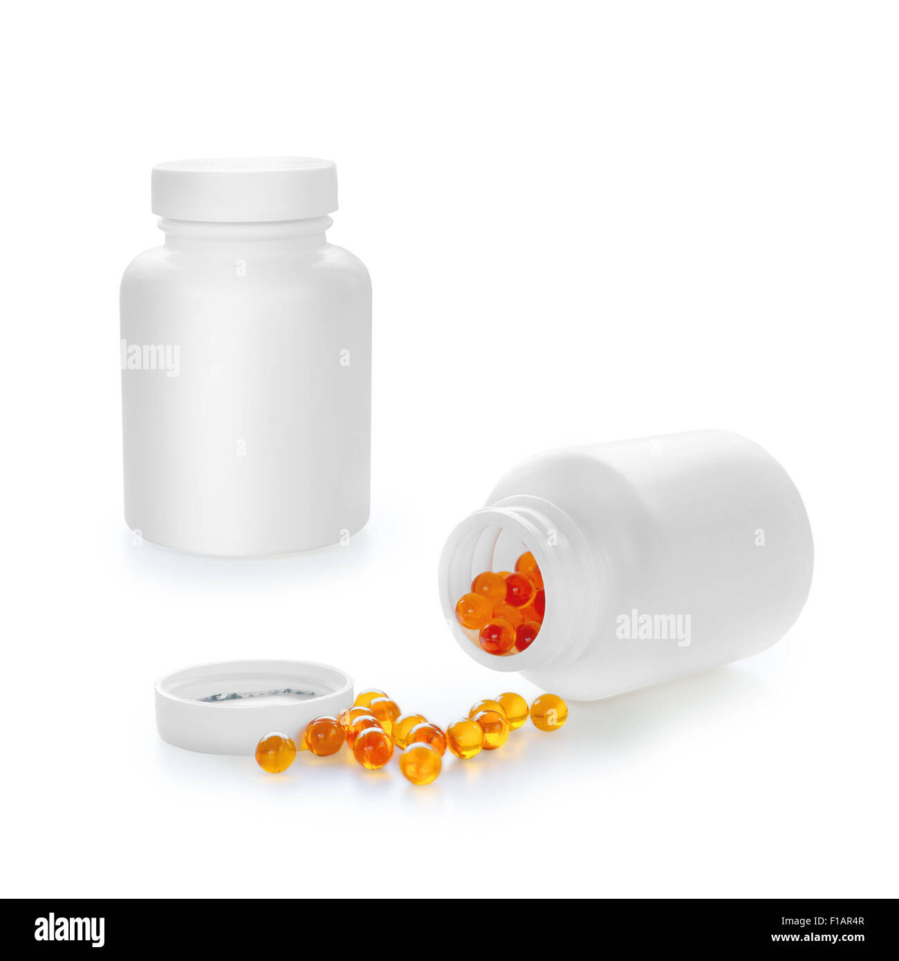 Weiße Flasche und orange Kapseln isoliert auf weißem Hintergrund mit Beschneidungspfad Stockfoto