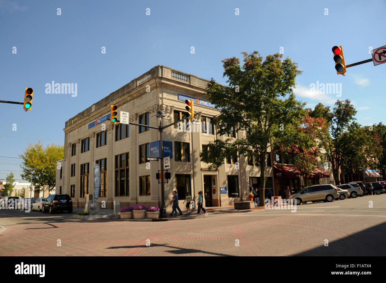 Straße und Fußgänger in Columbus, Indiana. Ecke Washington / 4. Straßen. Bankgebäude an der Ecke. Stockfoto