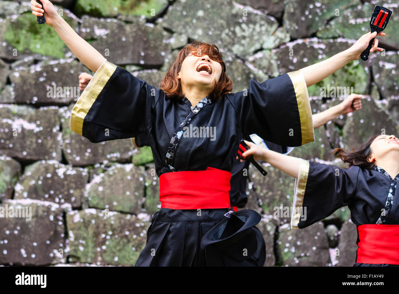 Japanische Frauen Yosakoi Tänzer tanzen in Schwarz yukata Jacke und Holding naruko, hölzerne Klöppel, mit Kopf nach hinten geworfen, und die Arme ausgestreckt. Stockfoto