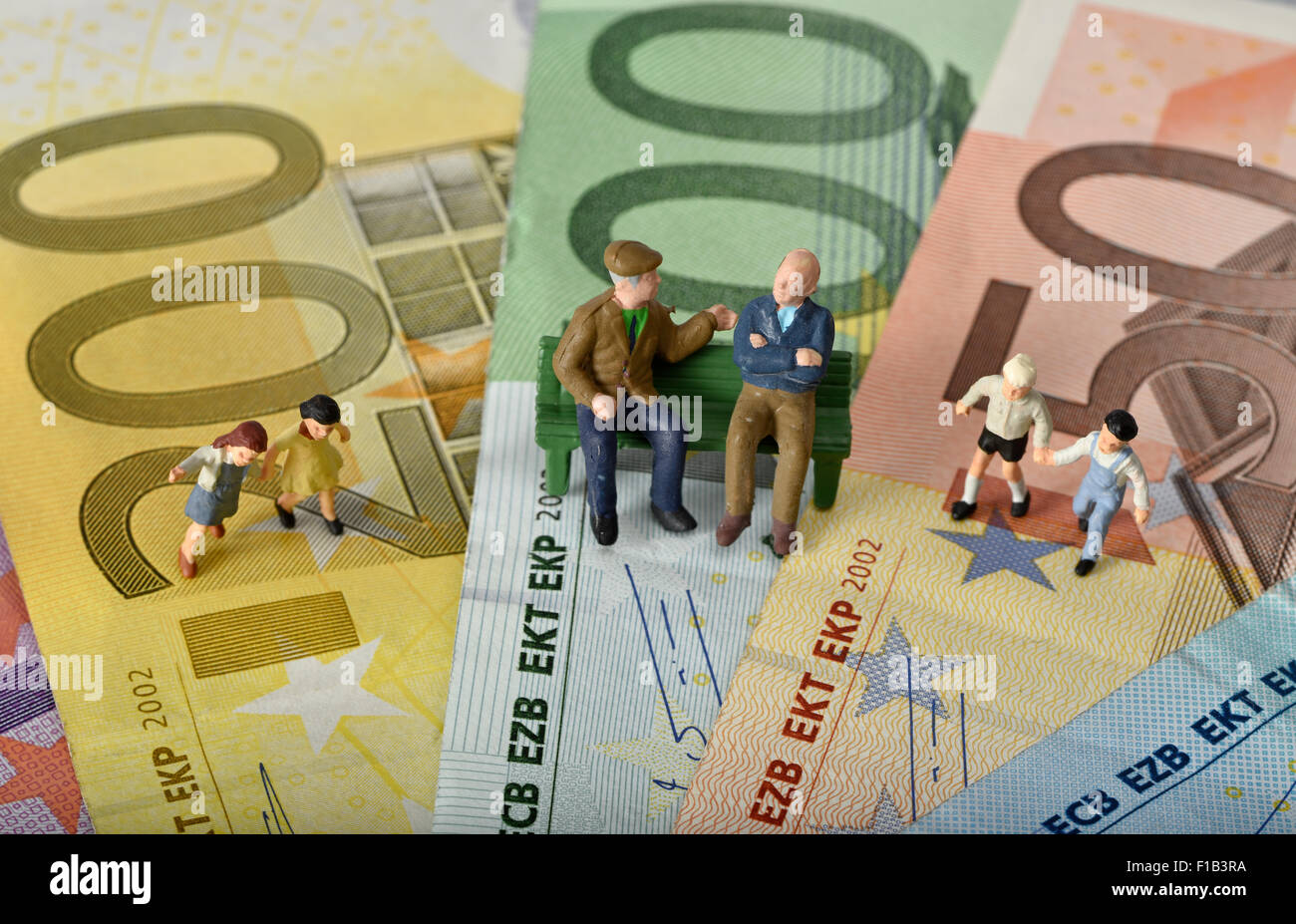 Alte Menschen sitzen auf einer Bank mit Kindern, pension Euro-Banknoten, Symbol für Generationen, Ruhestand, Stockfoto