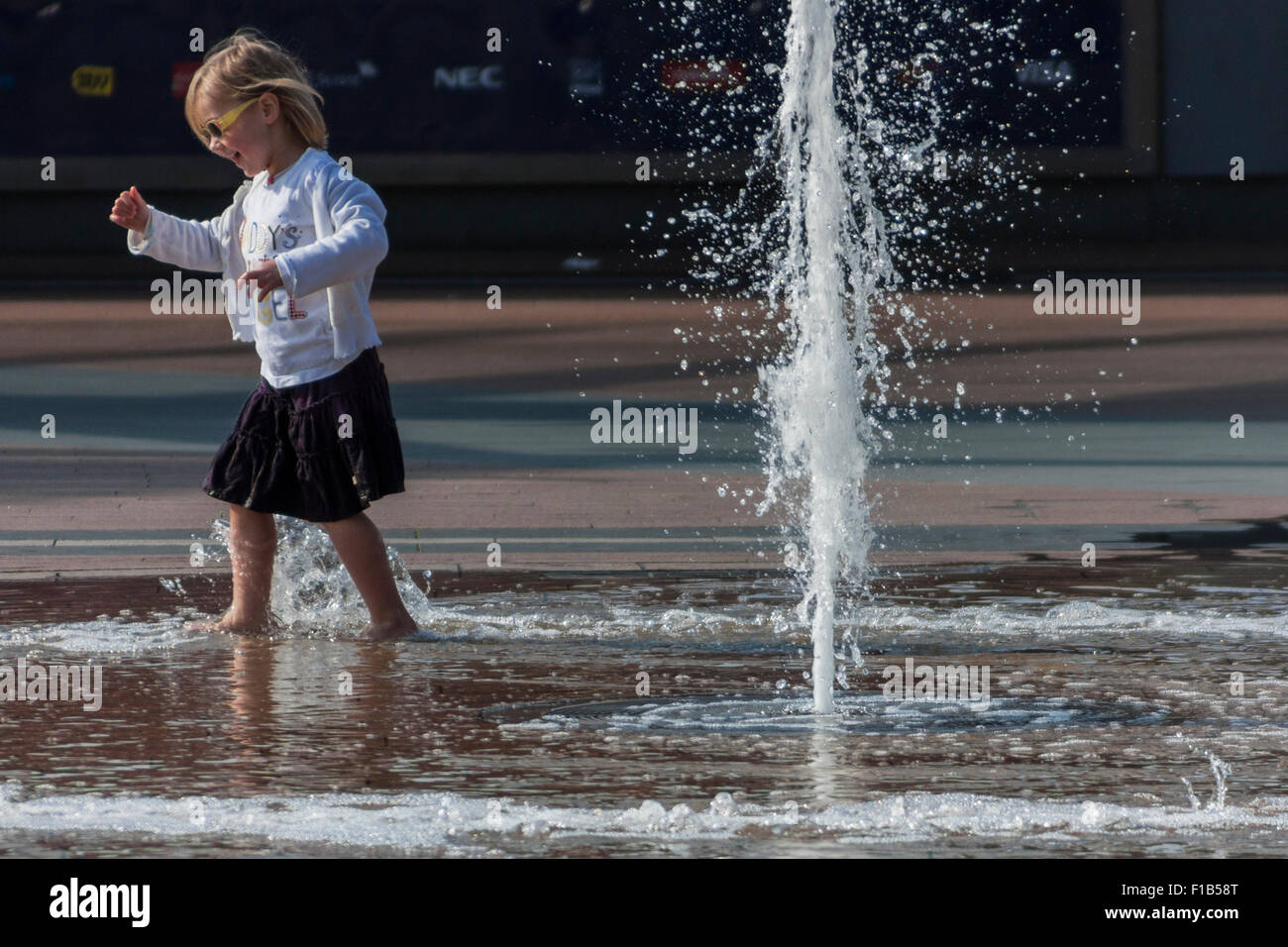 Mädchen spielen in den Brunnen in der Nähe der O2 Arena, North Greenwich, London, England, Vereinigtes Königreich Stockfoto