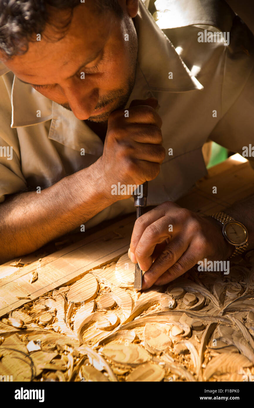 Indien, Jammu & Kaschmir, Srinagar, Altstadt, Handwerk, Hände des Holzschnitzers schnitzen traditionelle organisches Muster in Walnuss-panel Stockfoto