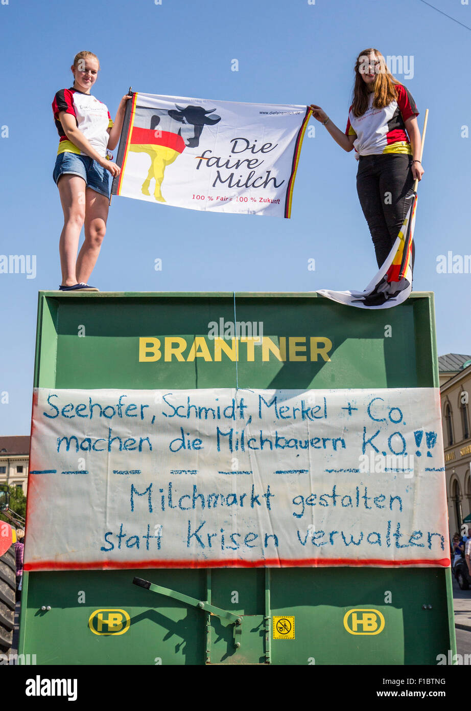 Landwirte protestieren gegen die Milch Preisverfall, am Odeon-Platz in München, 1. September 2015. Zwei Frauen halten einen Banner, das liest "Die faire Milch" ("Faire Milch sterben"). Foto: MARC Müller/dpa Stockfoto