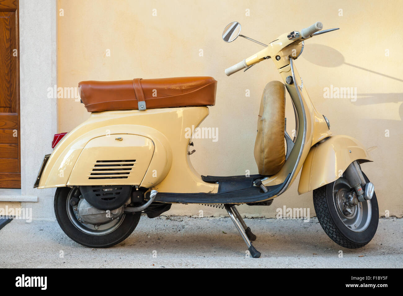 Gaeta, Italien - 19. August 2015: Klassische gelbe Vespa-Roller steht in der Nähe der Wand geparkten Stockfoto