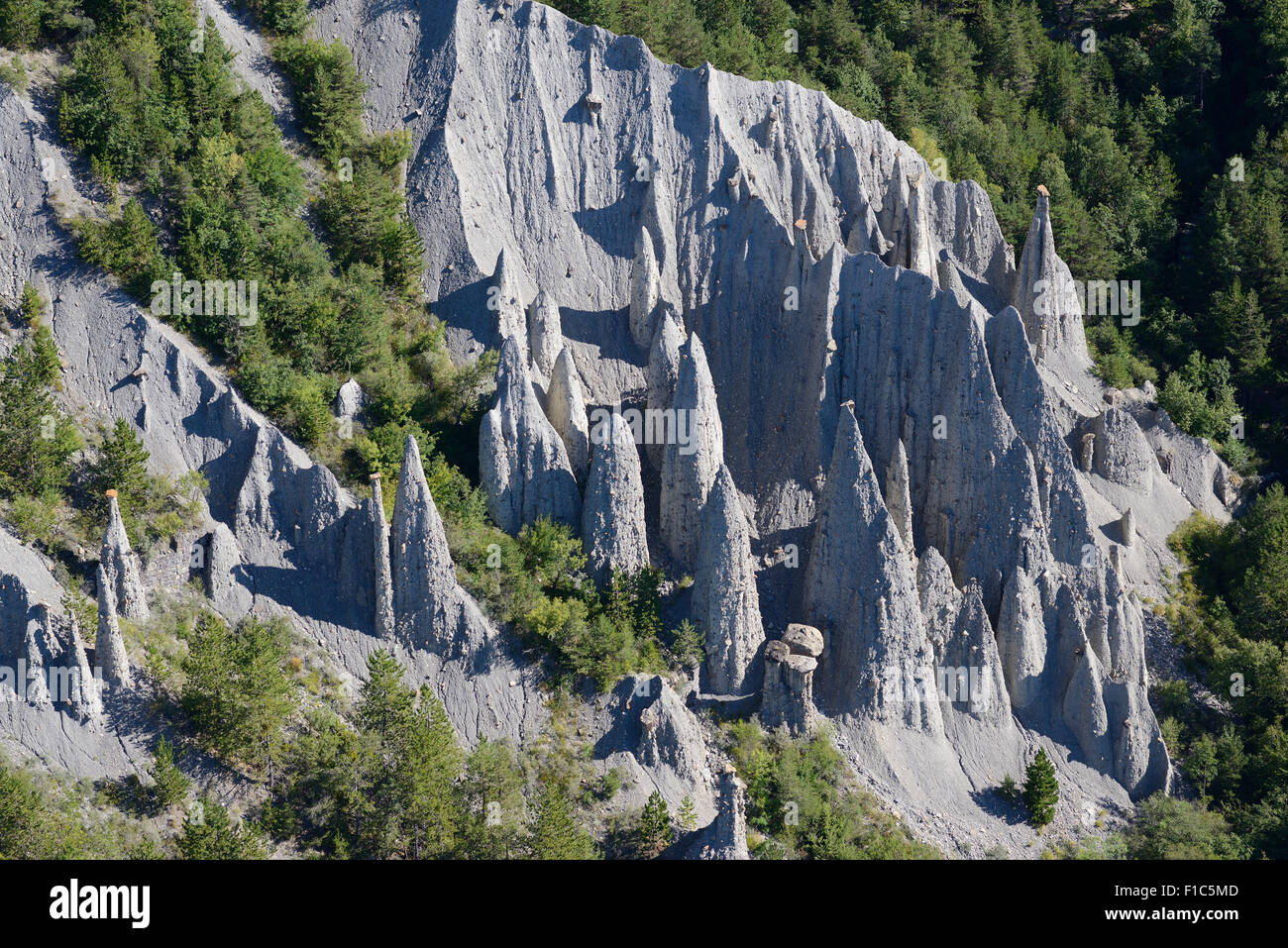 LUFTAUFNAHME. Geologische Neugier bekannt als demoiselles coiffées (Hoodoos) in der Nähe des Sees Serre-Ponçon. Théus, Hautes-Alpes, Frankreich. Stockfoto