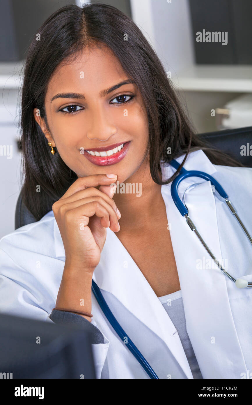 Eine indische asiatischen weiblichen Arzt in einem Krankenhaus Büro glücklich und lächelnd mit Stethoskop Stockfoto