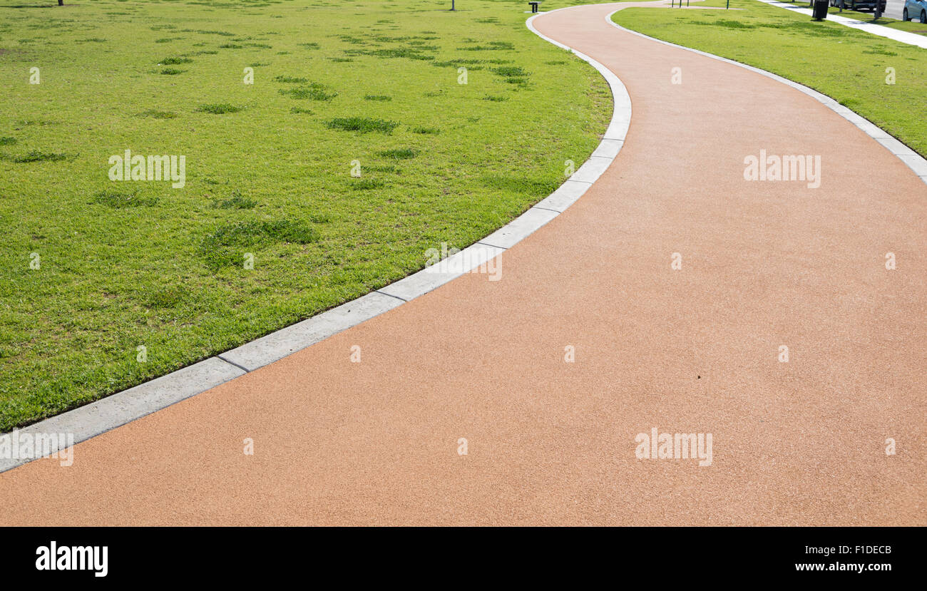 Ein Wanderweg in einem Park machen eine s-Kurve mit grass Stockfoto